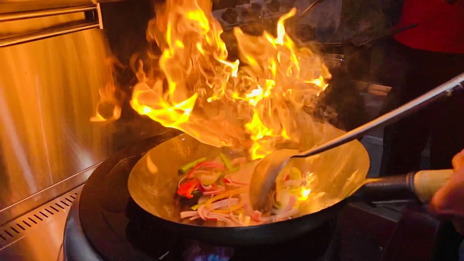 Sizzling Sri Lankan platter with flambé flame over charred meat and colourful vegetables